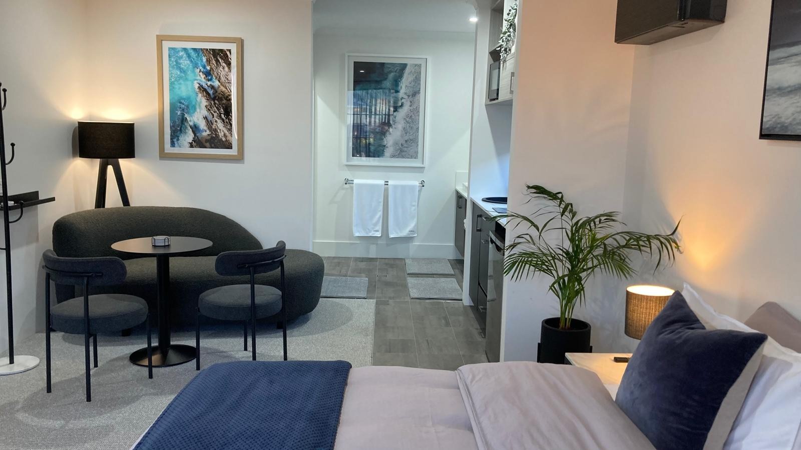Wide view across the BRiX suite showing the king bed, seating and entry